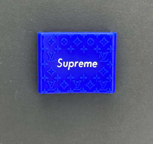 Supreme logo on a blue Louis Vuitton inspired grip accessory against a black background.