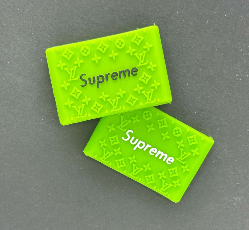 Bright green Supreme grip blocks featuring logo patterns, perfect for enhancing barbering precision and comfort.