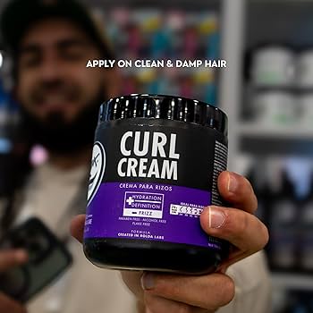 Person holding a jar of 'Curl Cream' with text on application.