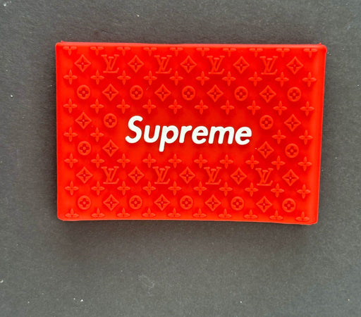 Red Supreme cardholder featuring Louis Vuitton pattern, designed for style and luxury.