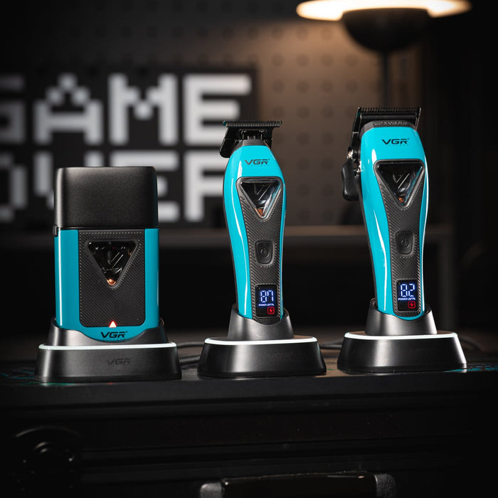 Three blue and black electric shavers on a dark surface with a blurred background.